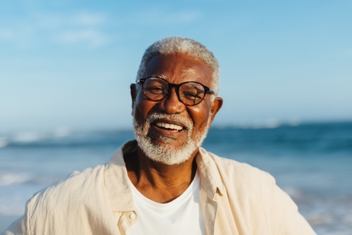 older African American man in glasses smiling 